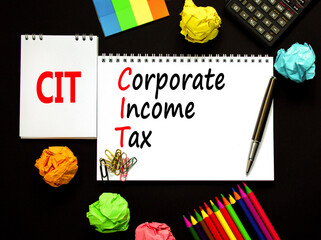 CIT corporate income tax symbol. Concept words CIT corporate income tax on white note on a beautiful black background. Calculator. Business and CIT corporate income tax concept. Copy space.