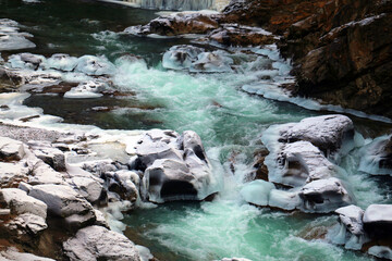 Photo of an unusual blue mountain river in snow