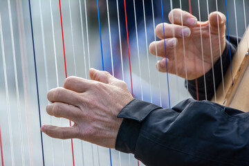 hands of a person playing the harp
