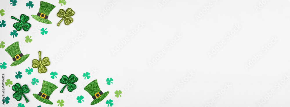 Poster st patricks day shamrock and green leprechaun hat corner border. overhead view over a white banner b