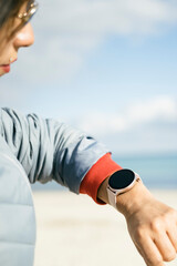 Waist up shot of happy brunette latin woman on smartwatch poses