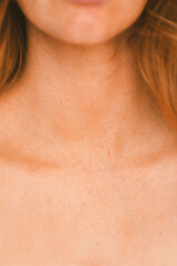 Upclose of a woman's neck and collarbones with freckles on skin