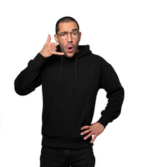 Amazed young man making a gesture of calling with the hand