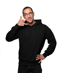 Hesitant young man making a gesture of calling with the hand