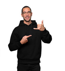 Happy young man making a gesture of calling with the hand