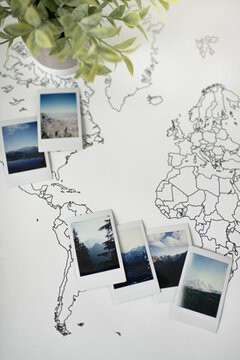 Mountain Polaroid Photos on Travel World Map with Plant Decor