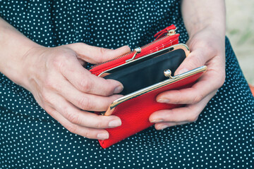 Opened red purse in female hands, selective focus.	