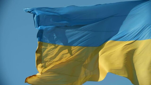 Ukrainian flag waving on the wind in the blue sky. High quality 4k footage. Blue and yellow colored flag close up
