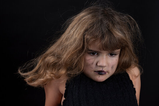 Portrait Of A Five Year Old Girl In Her Own Black Make Up In A Black Hat On The Black Background