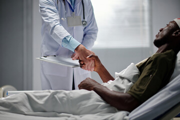 Doctor shaking hand of soldier and telling thank you for your service