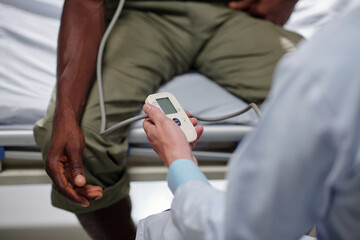 Fototapeta na wymiar Close-up image of doctor measuring blood pressure of military man