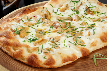Crispy Gourmet Pizza with porcini mushrooms, cheese and arugula leaves on wooden kitchen boards.