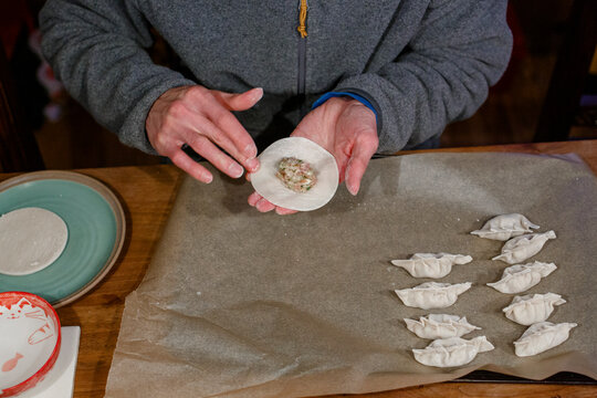 Close-up of man forming platter of Chinese dumplings