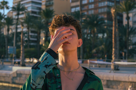Stylish alternative young man put his hand on the face
