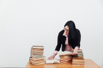 female teacher student at the table looking in a book article reads a book