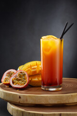 A refreshing cocktail in a glass with passion fruit and mango .