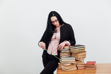 a teacher with a school pointer points to a stack of books to read