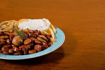 sausage, onion ring, egg and fries with salad