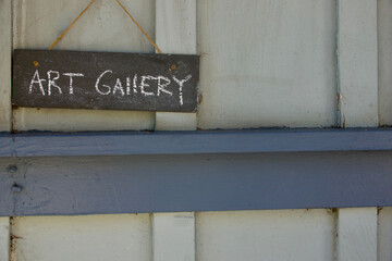 minimalist art gallery sign hanging from a nail