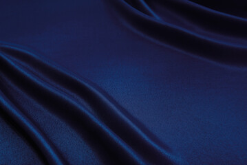 Texture of a smooth luxurious, elegant fabric in burgundy, purple, blue. blue satin or silk fabric with folds and waves
