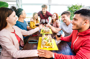Happy young people having fun together drinking wine at penthouse on private home party - Trendy friends enjoying time together at restaurant lounge - Dinning life style concept on bright vivid filter