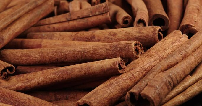 Cinnamon sticks rotate as a background. Fragrant cinnamon close-up. Spices with cinnamon. Food cooking video concept.