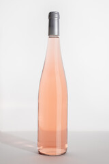 Rose wine bottle on table on white background, side view. Mock up product alcoholic drink,...