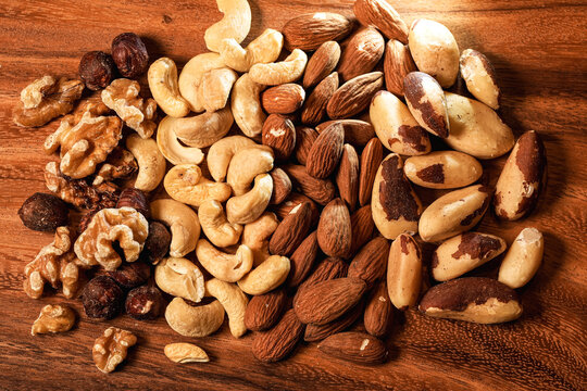 Nuts, cashews, almonds and Brazilian nuts from above. Mix with different types of nuts on a wooden plate. Close up healthy food with proteins.