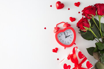 Women day presents concept. Flat lay photo of red roses, heart shaped alarm clock, gift box, hearts on white background with copy space. 8-march holiday card idea.