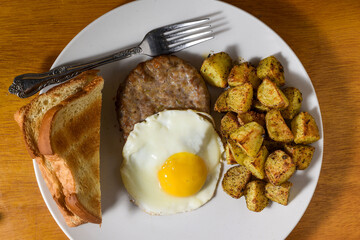 fried egg  with sausage  with a side of home fries