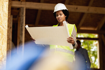 Black Woman Architect Checking Blueprints Project At Construction Site