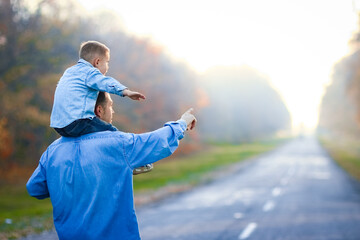 A Happy parent with child are walking along the road in the park on nature travel