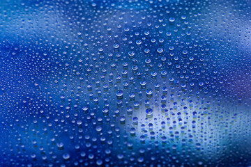 Fototapeta na wymiar Water drops. Abstract gradient background. Drop texture. Dark blue gradient. Heavily textured image. Shallow depth of field. Selective focus