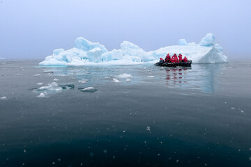 Expedition team near an iceberg