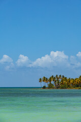 Wide angle view of the sea and beach in Playa Fronton in LAs Galeras, Dominican Republic. Turquoise blue sea, palms, tropical summer mood.