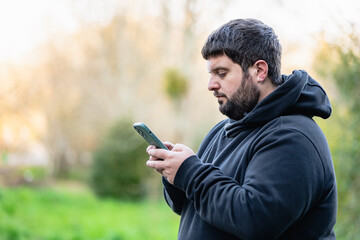 obese young man with hearing impairment, writes a text message