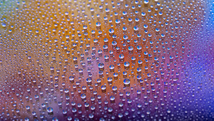 Water drops. Droplet texture. Abstract gradient background. Multicolored blue-gold rainbow gradient. Heavily textured image. Shallow depth of field. Selective focus
