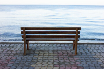 Naklejka na ściany i meble Bench in front of seaside. Wooden bench for watching blue and clean sea. Beach Bench Seat with the beautiful sea and coast view.