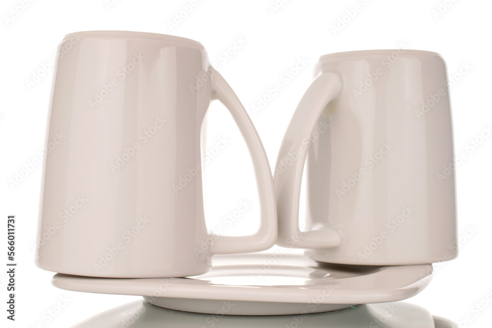 Wall mural Two empty ceramic white cups on saucer, macro, isolated on white background.