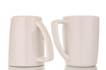 Two empty ceramic white cups, macro, isolated on white background.