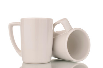 Two empty ceramic white cups, macro, isolated on white background.