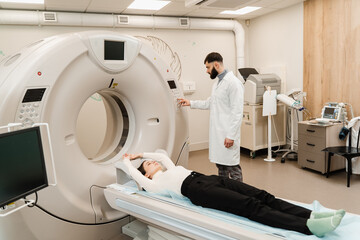 Girl patient is doing CT computed tomography x-ray scan of chest for examination of abdomen in a CT...