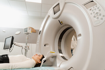 CT scan of brains of woman in medical clinic. Girl patient is doing computed tomography x-ray...