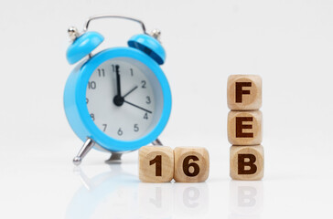 On a white background, a blue alarm clock and a calendar with the inscription - February 16