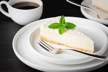 Cheesecake and coffee on a black wooden table