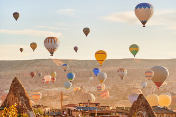 Landscape of fabulous Kapadokya. Colorful flying air balloons in sky at sunrise in Anatolia....