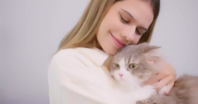 Portrait cute pretty young beautiful woman hugging embrace cute little fluffy cat, Relationship between pets and people. fluffy cat in the arms of his pet owner.