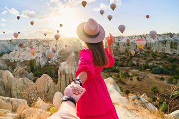 Girl traveler vacations beautiful destination in Goreme, Turkey. Follow me to fabulous Kapadokya with flying air balloons at sunrise, Anatolia