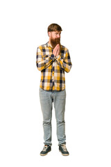 Young adult redhead man with a long beard standing full body isolated making up plan in mind, setting up an idea.