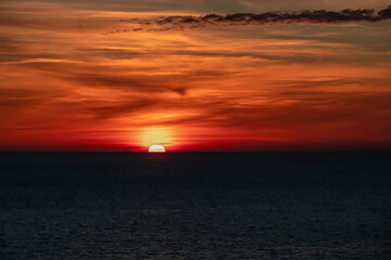 Panoramic sunset view from Sveti Stefan at Adriatic Mediterranean Sea, Budva Riviera, Montenegro, Europe. Reflection of sun beams on water surface during twilight. Summer vacation in seaside resort